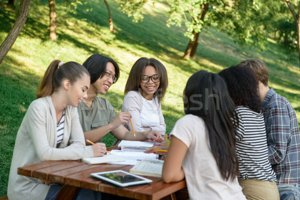 Jungen Studenten Sitzung Studium Freien sprechen Stock foto © deandrobot