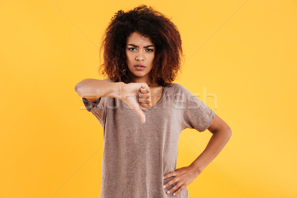 Young angry unhappy woman showing thumb down isolated Stock photo © deandrobot
