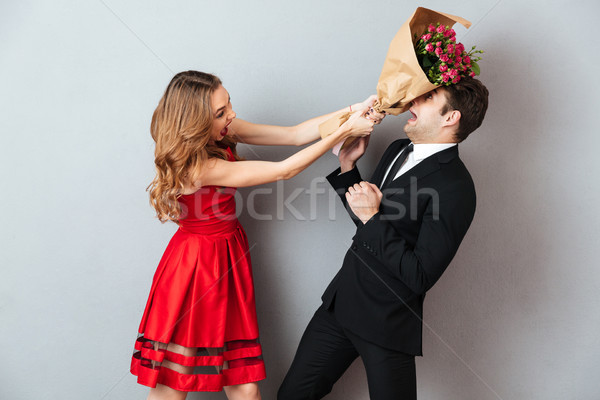 Portrait of an angry woman beating up a man Stock photo © deandrobot