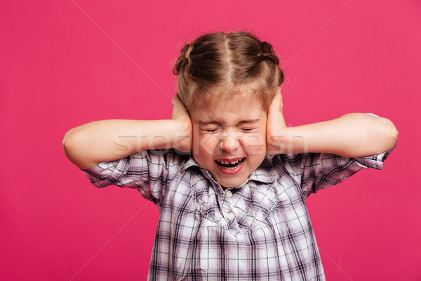 Screaming emotional little girl child holding head with hands. Stock photo © deandrobot