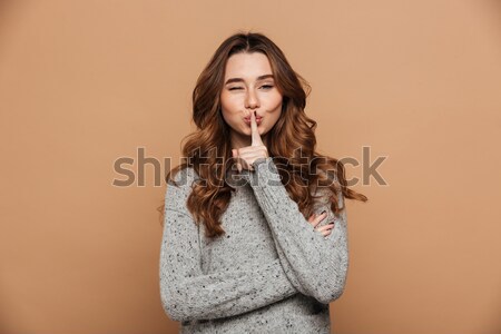 Charming brunette woman with curly hair standing with hands fold Stock photo © deandrobot