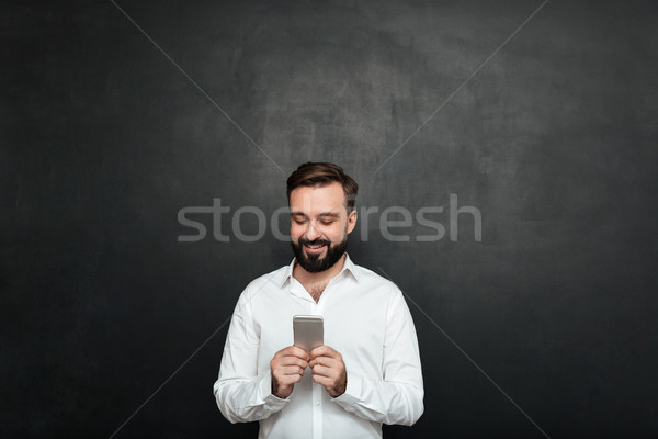 Pleased office worker in white shirt typing text message or scro Stock photo © deandrobot