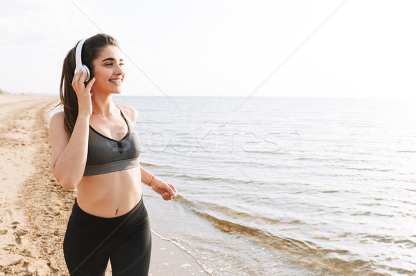 Bastante jovem corrida praia ouvir música Foto stock © deandrobot