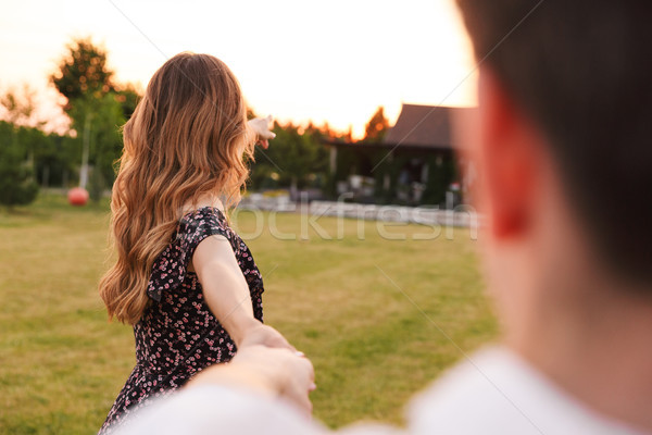 Photo from back of loving young woman holding hand of attractive Stock photo © deandrobot