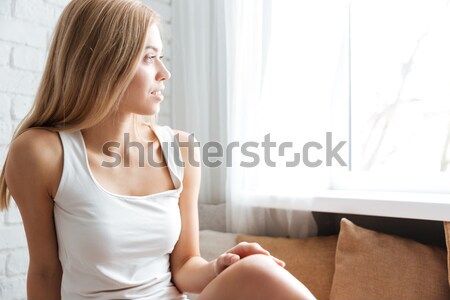 Young woman with hot water bottle on stomach on the bed Stock photo © deandrobot