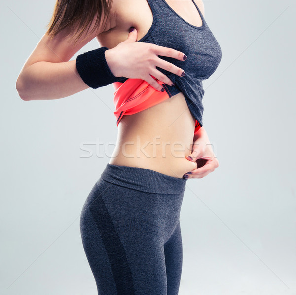 Fitness woman pinch a fat on her abdomen Stock photo © deandrobot