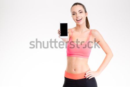Happy fitness woman holding bottle with water Stock photo © deandrobot