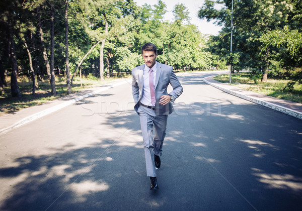 Businessman running in park Stock photo © deandrobot