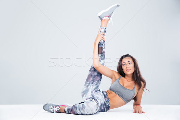 Fitness woman stretching legs on the floor Stock photo © deandrobot