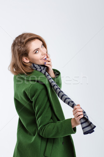 Woman in green coat looking back at camera Stock photo © deandrobot