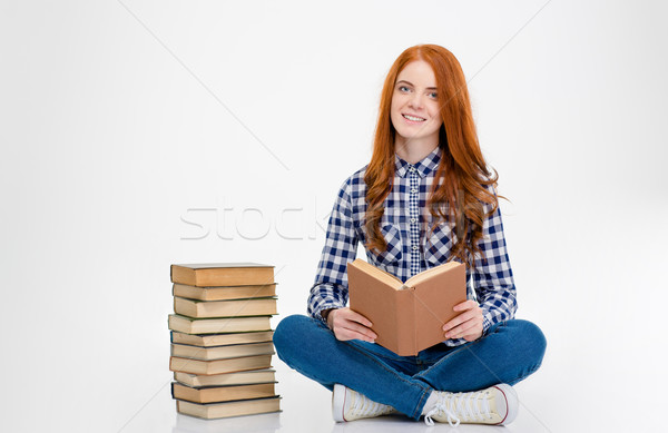 Inspired woman sitting near stack of the books and reading Stock photo © deandrobot