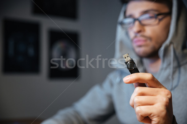 Handsome man in glasses sitting and holding usb cable Stock photo © deandrobot