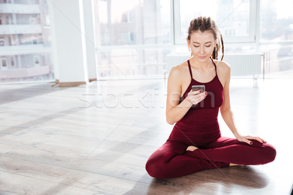 çekici mutlu genç kadın yoga cep telefonu oturma Stok fotoğraf © deandrobot