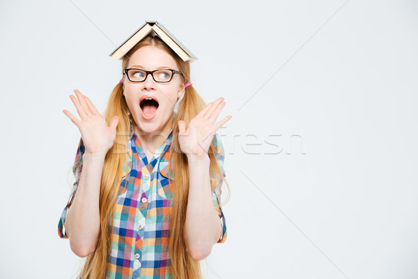 Amazed female student with book on head Stock photo © deandrobot