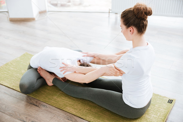 Two women sitting and stretching in yoga center Stock photo © deandrobot