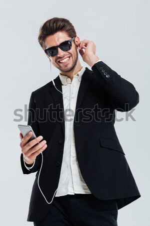 Businessman in suite and sunglasses looking at whiskey in glass Stock photo © deandrobot