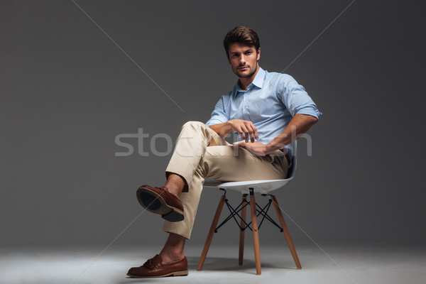 Relaxed handsome man in blue shirt sitting on the chair Stock photo © deandrobot