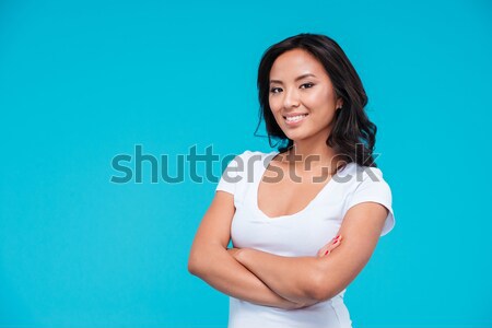 Young happy asian woman standing with arms folded Stock photo © deandrobot