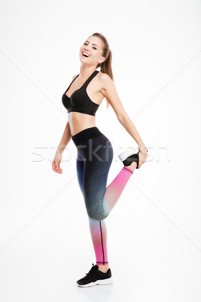 Portrait of a beautiful fitness woman doing stretching exercises Stock photo © deandrobot