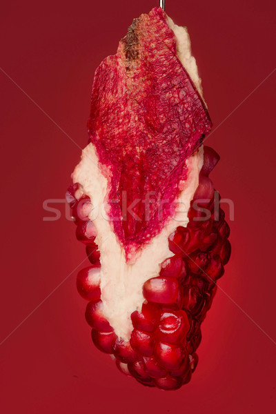 Pomegranate piece on red background Stock photo © deandrobot