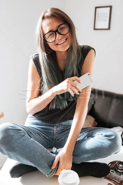 微笑的女人 坐在 雙腿交叉 手機 微笑 美麗 商業照片 © deandrobot