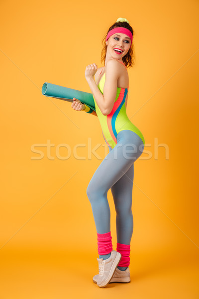 Young sports lady posing over yellow background. Stock photo © deandrobot