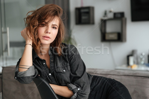 Pretty woman sitting on chair at home indoors Stock photo © deandrobot
