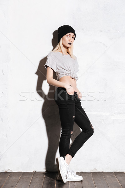 Attractive young woman in black hat standing and posing Stock photo © deandrobot