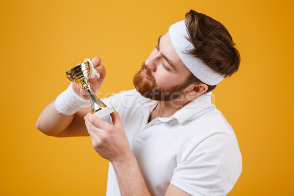 Handsome young sportsman holding reward and wipe with a napkin Stock photo © deandrobot