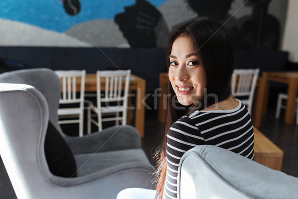 Back view of Asian woman sitting in cafeteria Stock photo © deandrobot