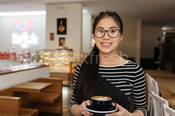 Asian barmaid with cup of coffee Stock photo © deandrobot