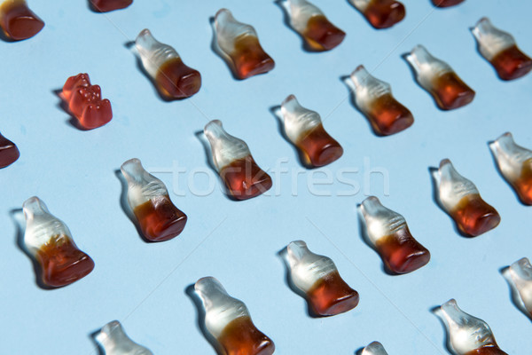 Sweeties chewing candy in bottle form over blue background. Stock photo © deandrobot