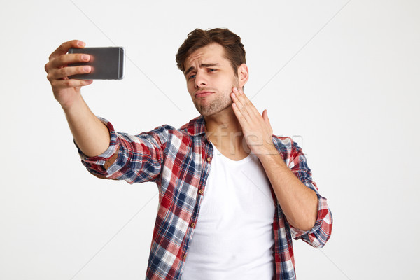 Portrait of a handsome confident man taking a selfie Stock photo © deandrobot
