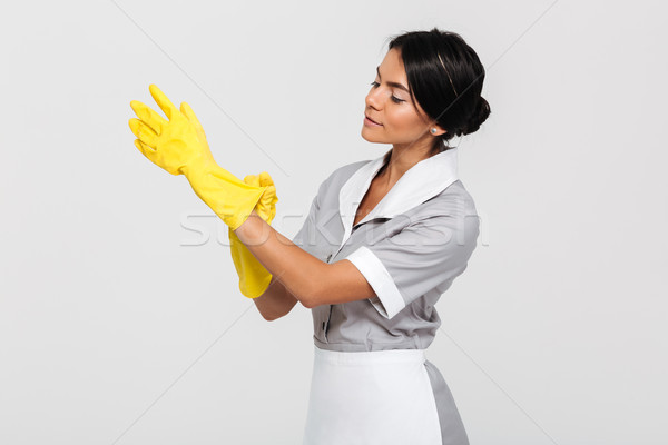 Fiatal kaukázusi házvezetőnő visel takarító kesztyű néz Stock fotó © deandrobot