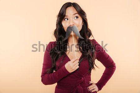 Portrait of elegant asian female in pretty maroon dress having f Stock photo © deandrobot