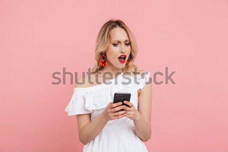 Stock photo: Portrait of a smiling playful girl holding mobile phone