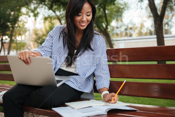 Close-up photo of young smiling asian female student, taking not Stock photo © deandrobot