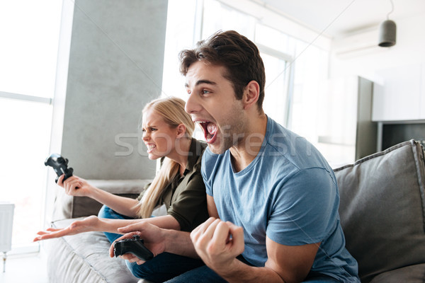 Jonge man tonen winnaar gebaar spelen vrouw Stockfoto © deandrobot