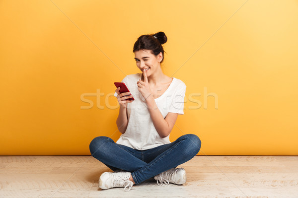 Portré játékos fiatal nő tart mobiltelefon ül Stock fotó © deandrobot