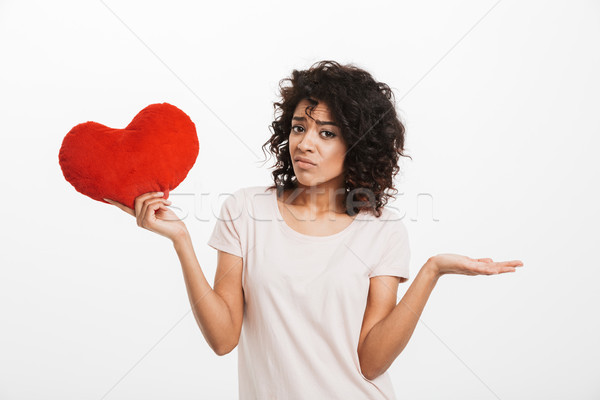 Picture of displeased american woman 20s with brown hair holding Stock photo © deandrobot