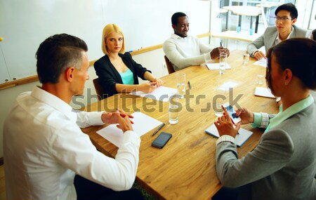 Businesspeople having meeting around table in office Stock photo © deandrobot