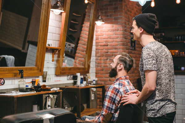 Smiling hairstylist and plesed man client looking in mirror Stock photo © deandrobot