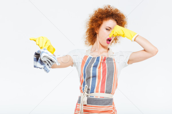 Unhappy woman closing nose by hand and holding dirty rag Stock photo © deandrobot