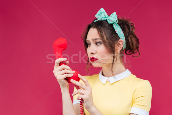 Sad pretty woman using red receiver and talking on telephone Stock photo © deandrobot