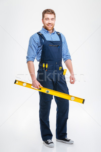 Smiling male builder holding waterpas Stock photo © deandrobot
