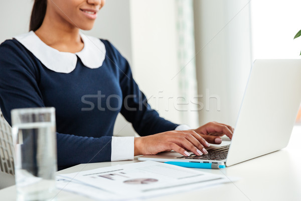 Young african business woman on workplace with water Stock photo © deandrobot