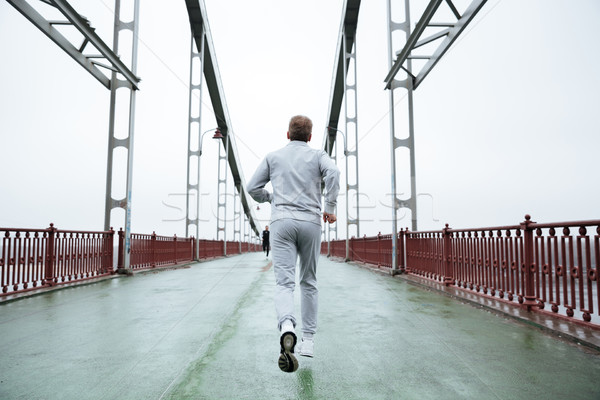 Back view of Elderly Man running on bridge Stock photo © deandrobot