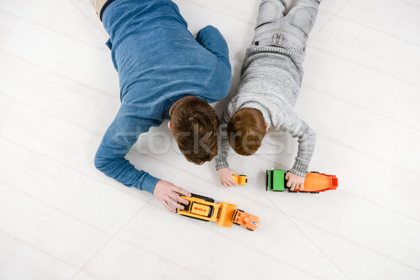 Top view of father playing toys with his little son Stock photo © deandrobot