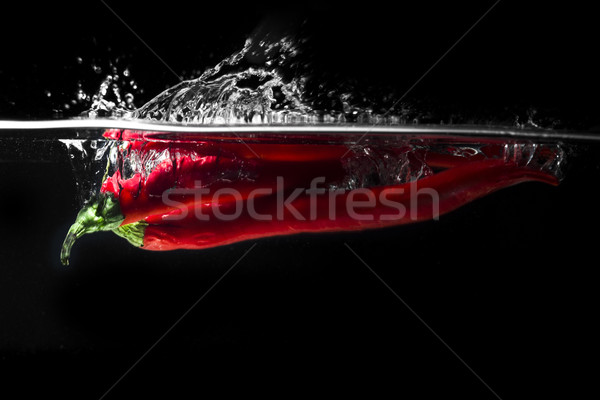 Piros chilipaprika zuhan víz izolált fekete Stock fotó © deandrobot