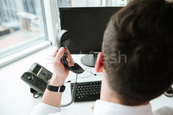 Back view of Man holding handset Stock photo © deandrobot